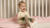 a little baby girl wearing a beige two piece set of merino clothing.