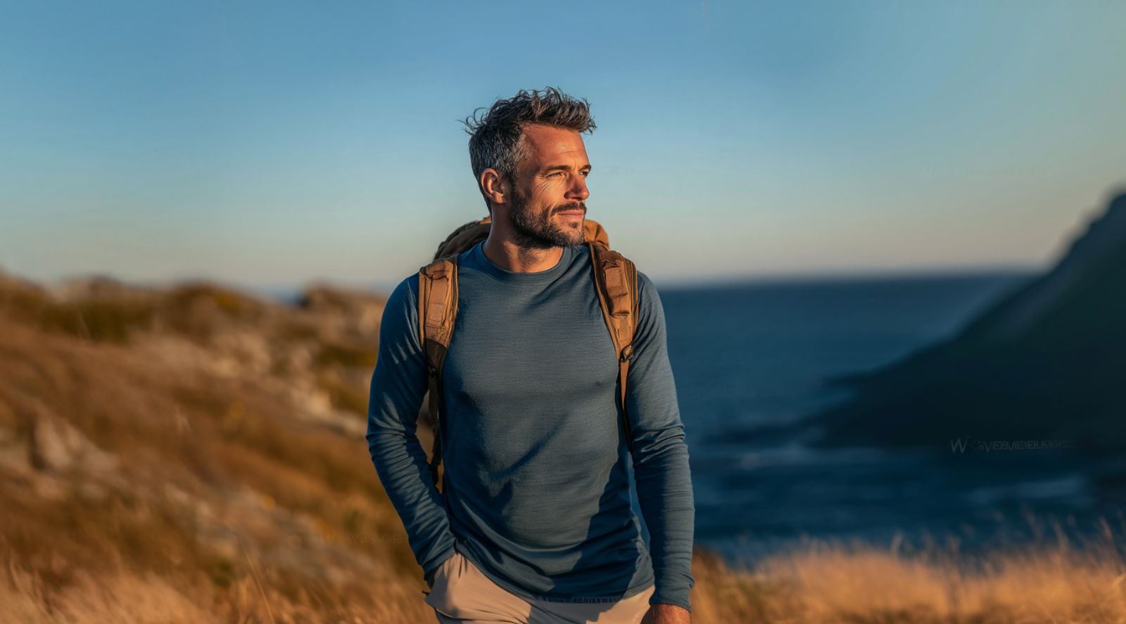 Handsome young man in Merino wool sports clothing long sleeve top standing outside. 
