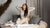 Woman sitting on the bed and wearing natural Merino wool matching set
