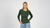 Woman wearing a green long-sleeve shirt and blue jeans on a white background